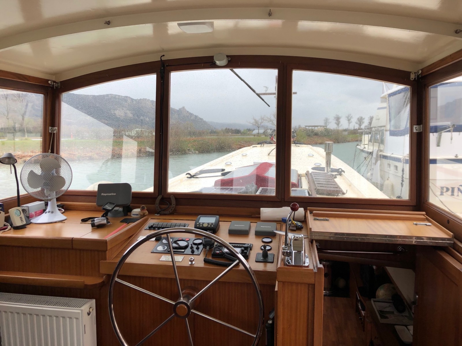 Vue intérieure de la timonerie d'une péniche dans la Drôme avec fenêtre équipée de films de protection solaire