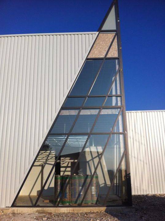 Pose de filtres solaires sur une vitrine d'accueil en forme de pyramide à Alixan, Drôme