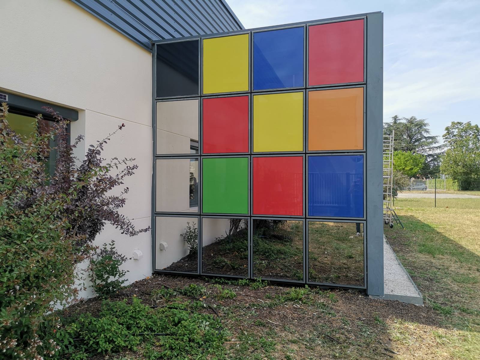 Collage d'un adhésif imprimé sur un film anti-chaleur pour la protection solaire des surfaces vitrées d'un local professionnel à Valence, en région Rhône-Alpes