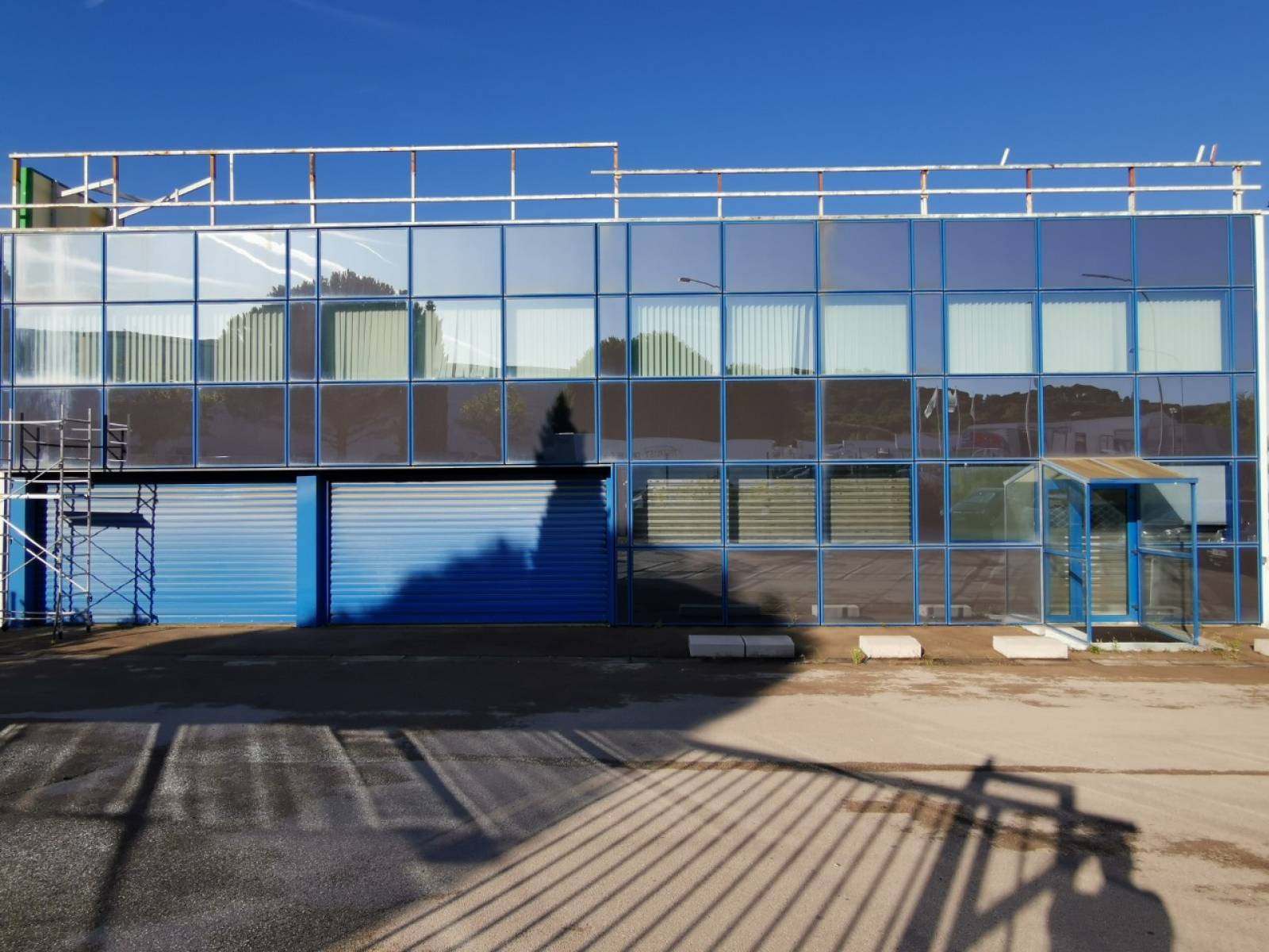 Façade vitrée avant pose de films solaires à effet miroir de l'usine Thermolaquage de Vitrolles, Bouches-du-Rhône