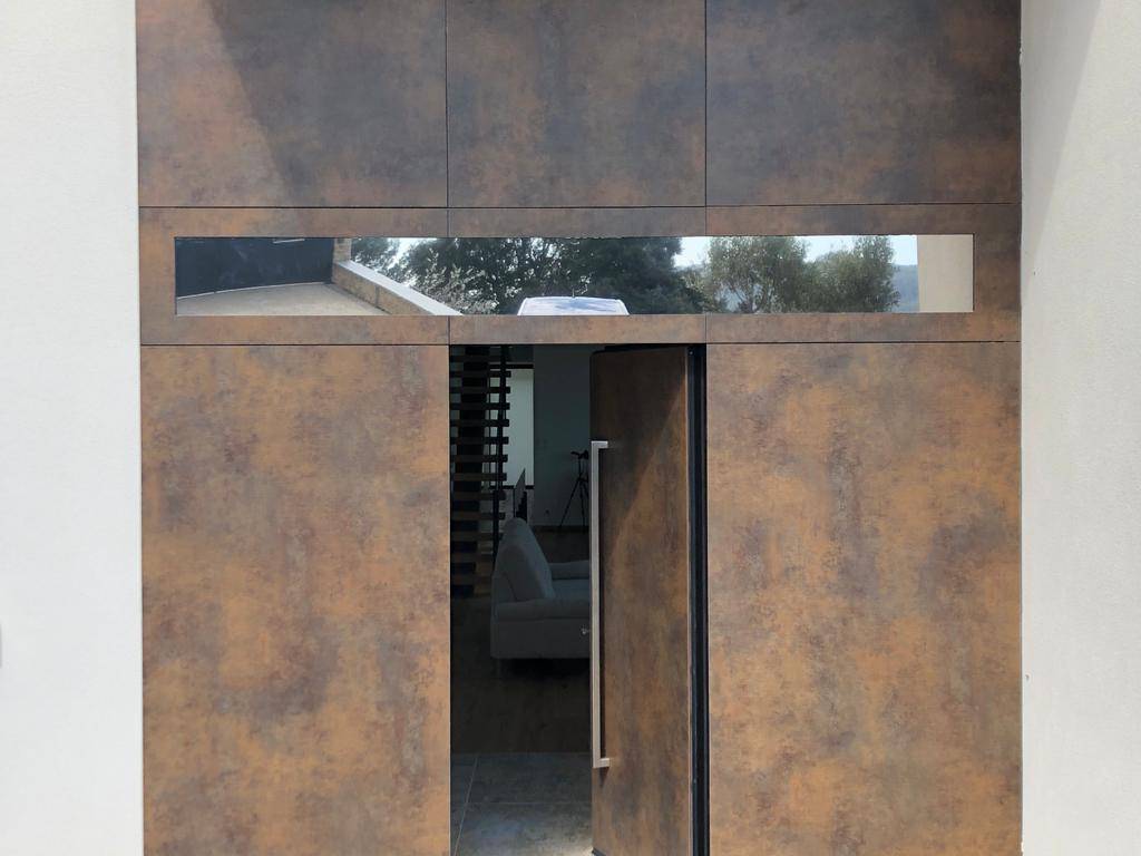 Porte vitrée d'une maison d'architecte protégée par un film solaire à effet miroir près de Valence