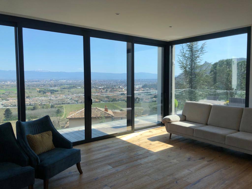 Baie vitrée d'une maison d'architecte protégée par un film anti chaleur près de Valence