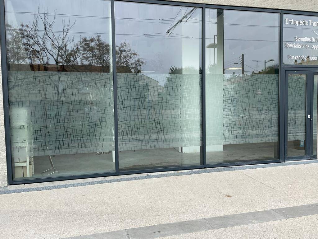 Vitrages extérieurs d'une usine près de Montpellier isolés des regards extérieurs grâce à l'application d'un film adhésif anti regards pré imprimé