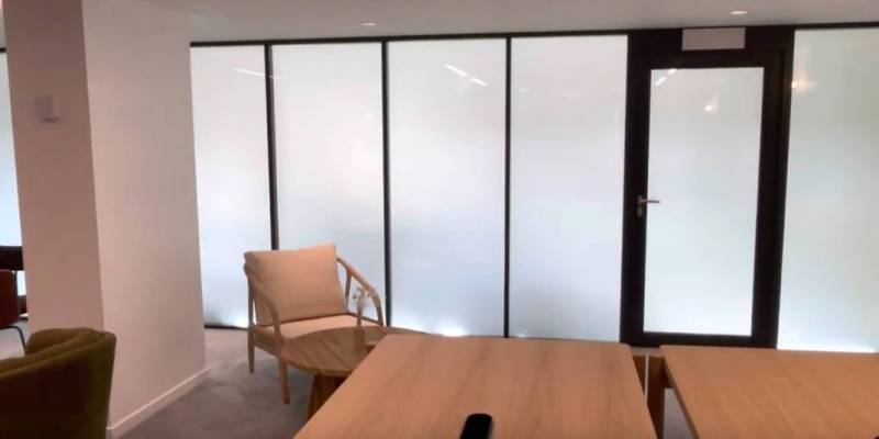 Pose de films connectés pour vitrage sur les cloisons vitrées d'une salle de réunion de bureaux à Paris 4ème 75004