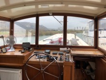 Vue intérieure de la timonerie d'une péniche dans la Drôme avec fenêtre équipée de films de protection solaire