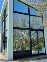 Film de contrôle solaire avec effet miroir installé sur les baies vitrées d'une maison contemporaine près de Bézier
