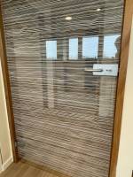 Design contemporain du film décoratif d'intimité installé sur la porte vitrée de bureaux dans l'Hérault